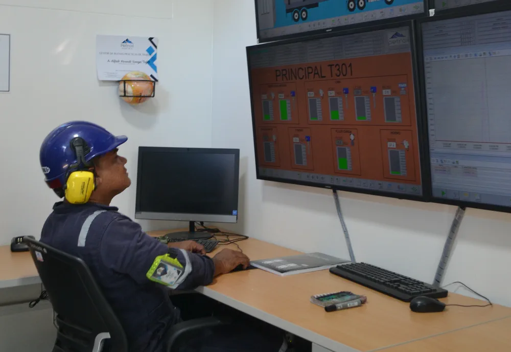 Operador de Petroil frente a los paneles del cuarto de control de la refinería.